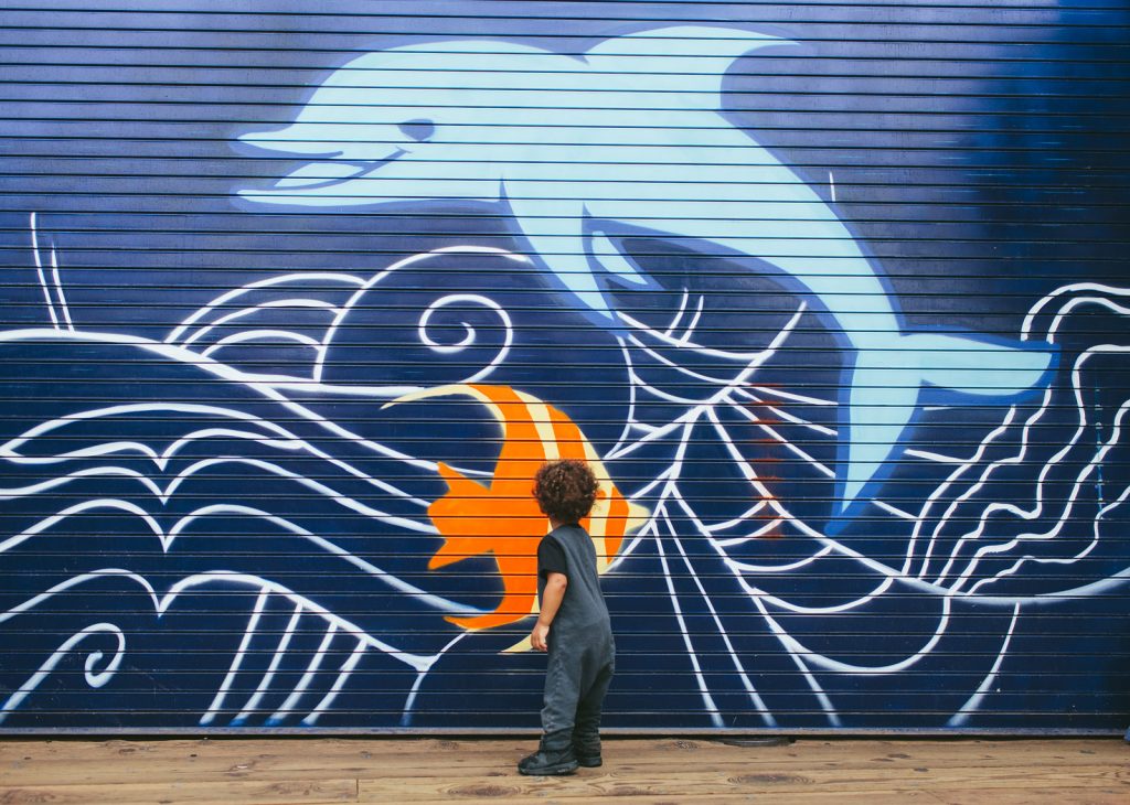 Cute little boy interested in a Santa Monica Pier marine life mural. Southern California family photographers, Birch Blaze Studios.
