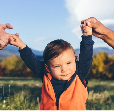 Little boy receives a helping hand from mom and dad.
