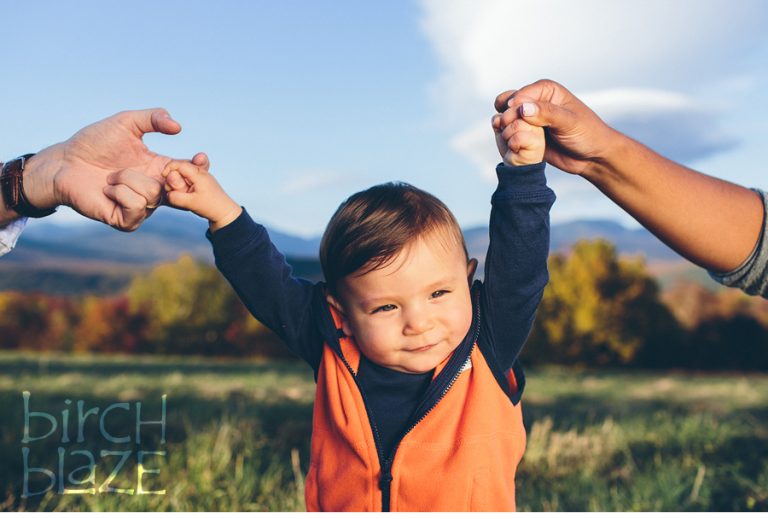 Little boy receives a helping hand from mom and dad.