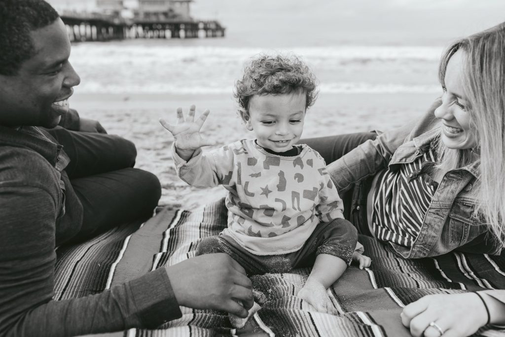 Black & white photo of a young boy on a southern California beach in Santa Monica. Family photography by Birchblaze.