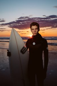 Young surfer portrait at sunrise, east coast. Hero shot. Birch Blaze Studios.