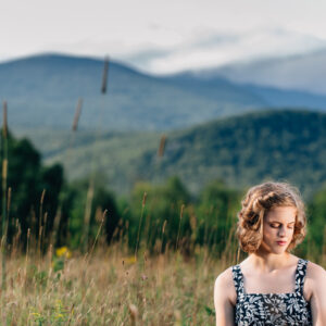 Young woman's mountain meadow, senior portrait session in Jackson, NH. Senior photos in the White Mountains by Birch Blaze Studios. © 2021 Birch Blaze Studios.